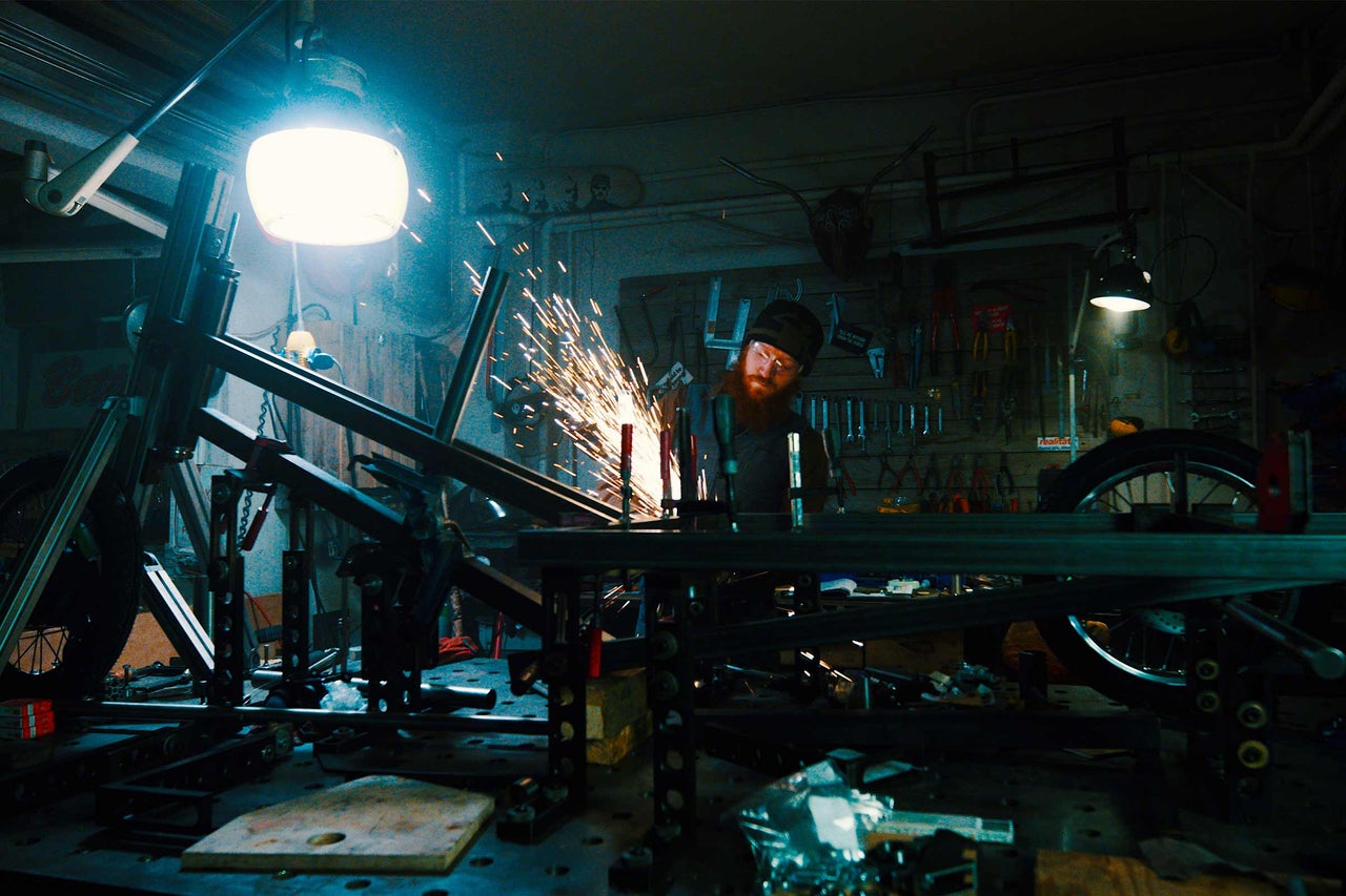 Atelier avec artisan soudant un cadre de moto