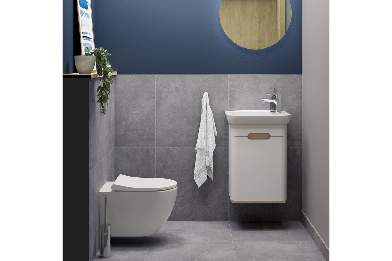 Salle de bains moderne avec WC suspendu, lavabo et miroir rond