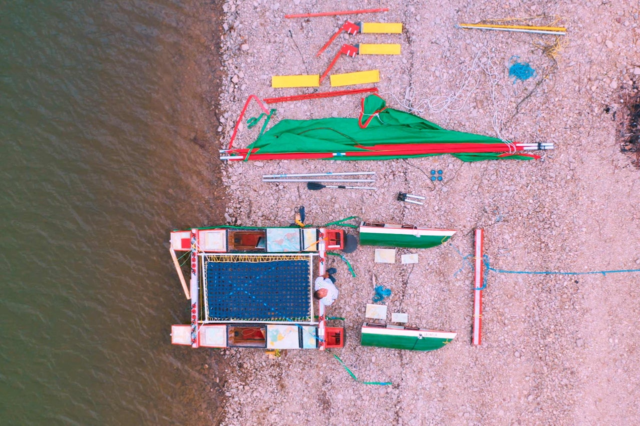 Vue aérienne d'un radeau assemblé à côté d'une rive de rivière avec l'équipement associé