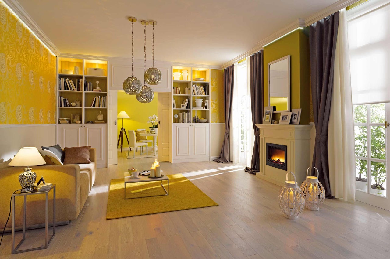 Salon avec canapé, bibliothèques, cheminée et lampes décoratives