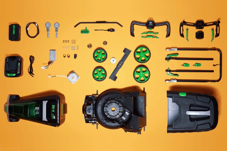 Pièces détachées d'une tondeuse à gazon sans fil sur fond jaune