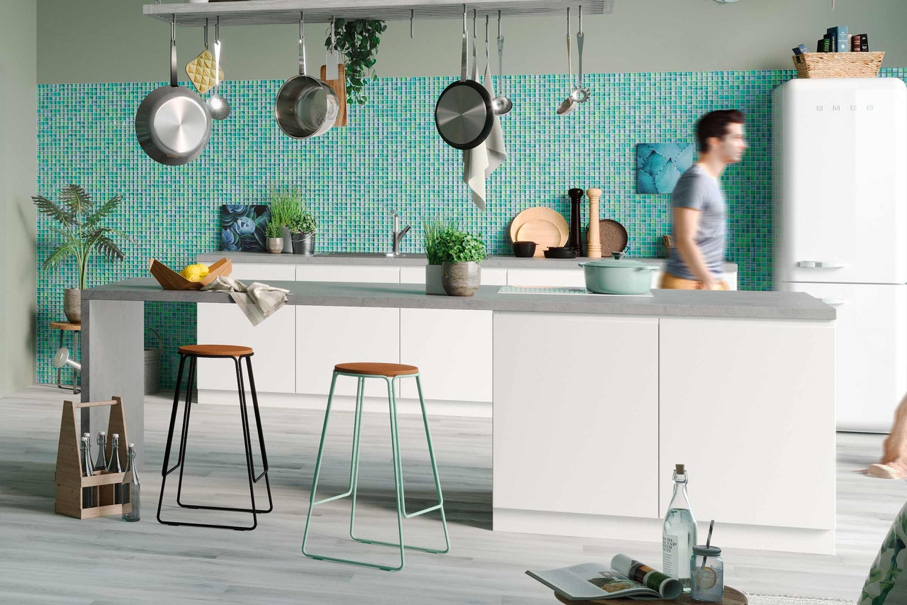 Cuisine lumineuse avec ustensiles de cuisine, carreaux de mosaïque et tabourets de bar