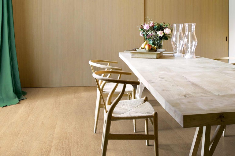 Salle à manger lumineuse avec table en bois, chaises et décoration