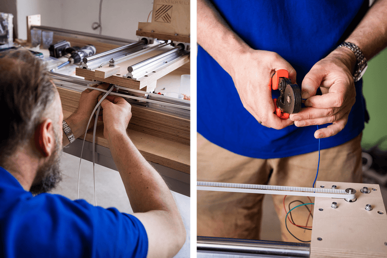 Ein Mann befestigt einen Zahnriemen an einer Holzkonstruktion und schneidet ein Kabel mit einem Werkzeug.