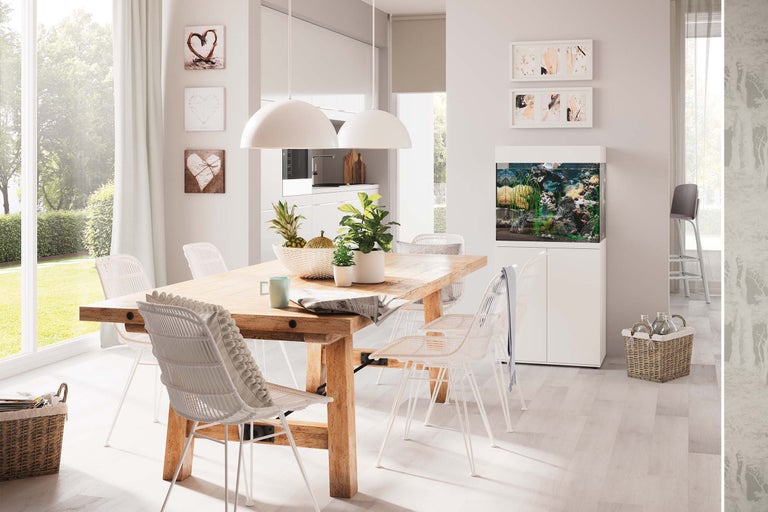 Salle à manger lumineuse avec table en bois, chaises en osier, aquarium et décorations