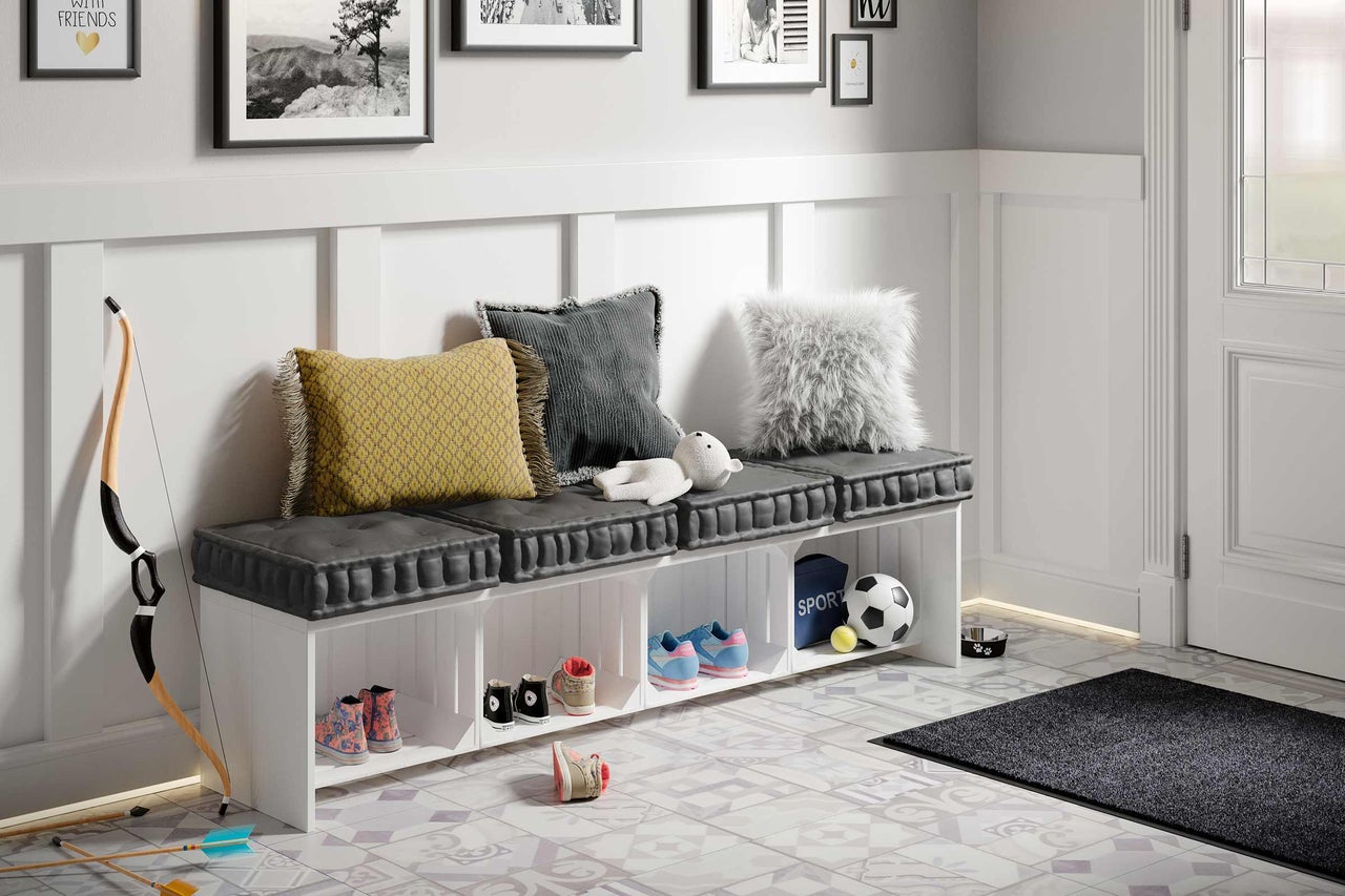 Hall d'entrée avec banc à chaussures, coussins et articles de décoration sur un sol à motifs