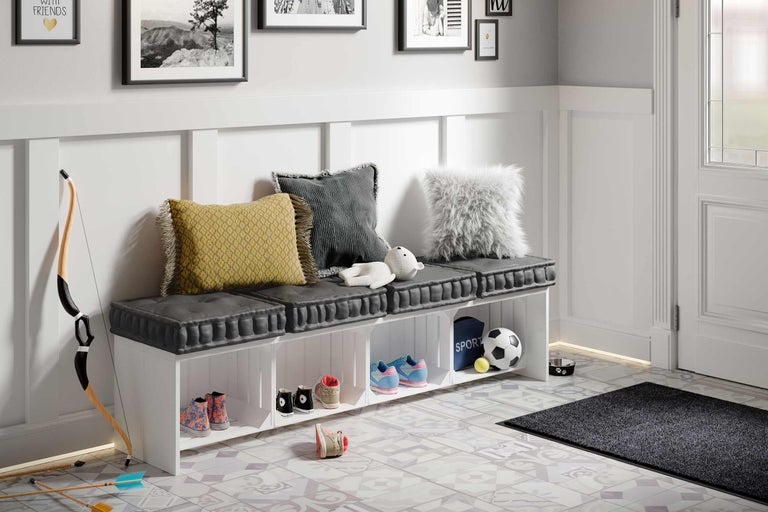 Hall d'entrée avec banc à chaussures, coussins et articles de décoration sur un sol à motifs