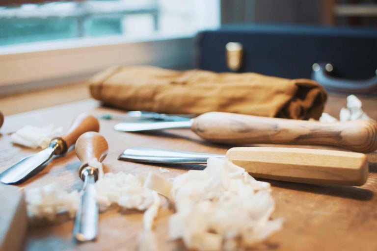 Stecheisen mit Holzgriffen auf einer Werkbank mit Holzspänen