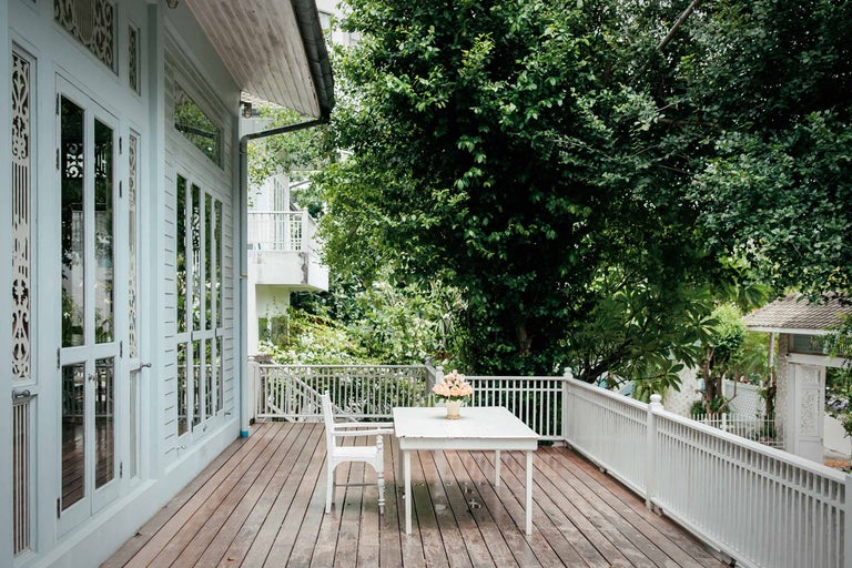 Veranda mit Holzboden, Tisch, Stuhl und Geländer