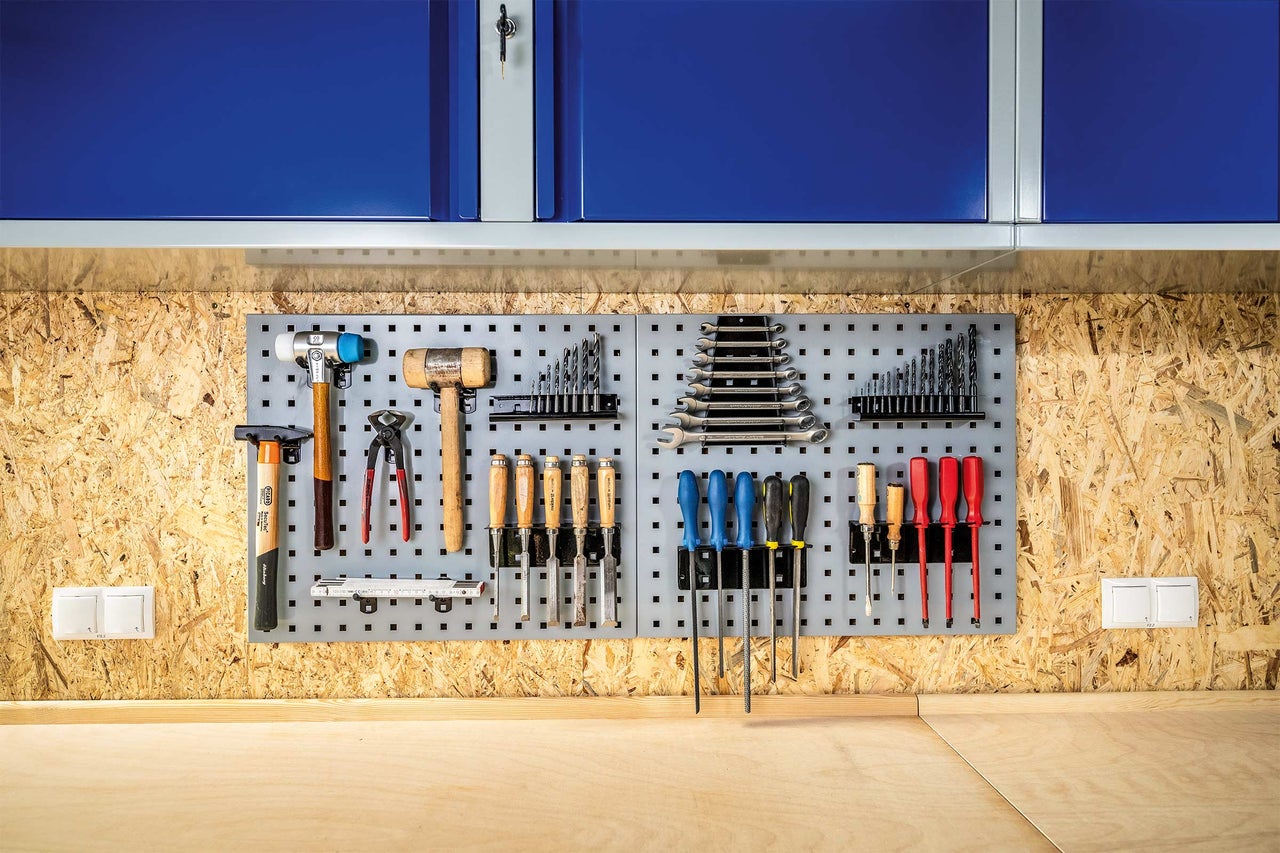 Atelier avec panneau à outils, armoire à outils et établi