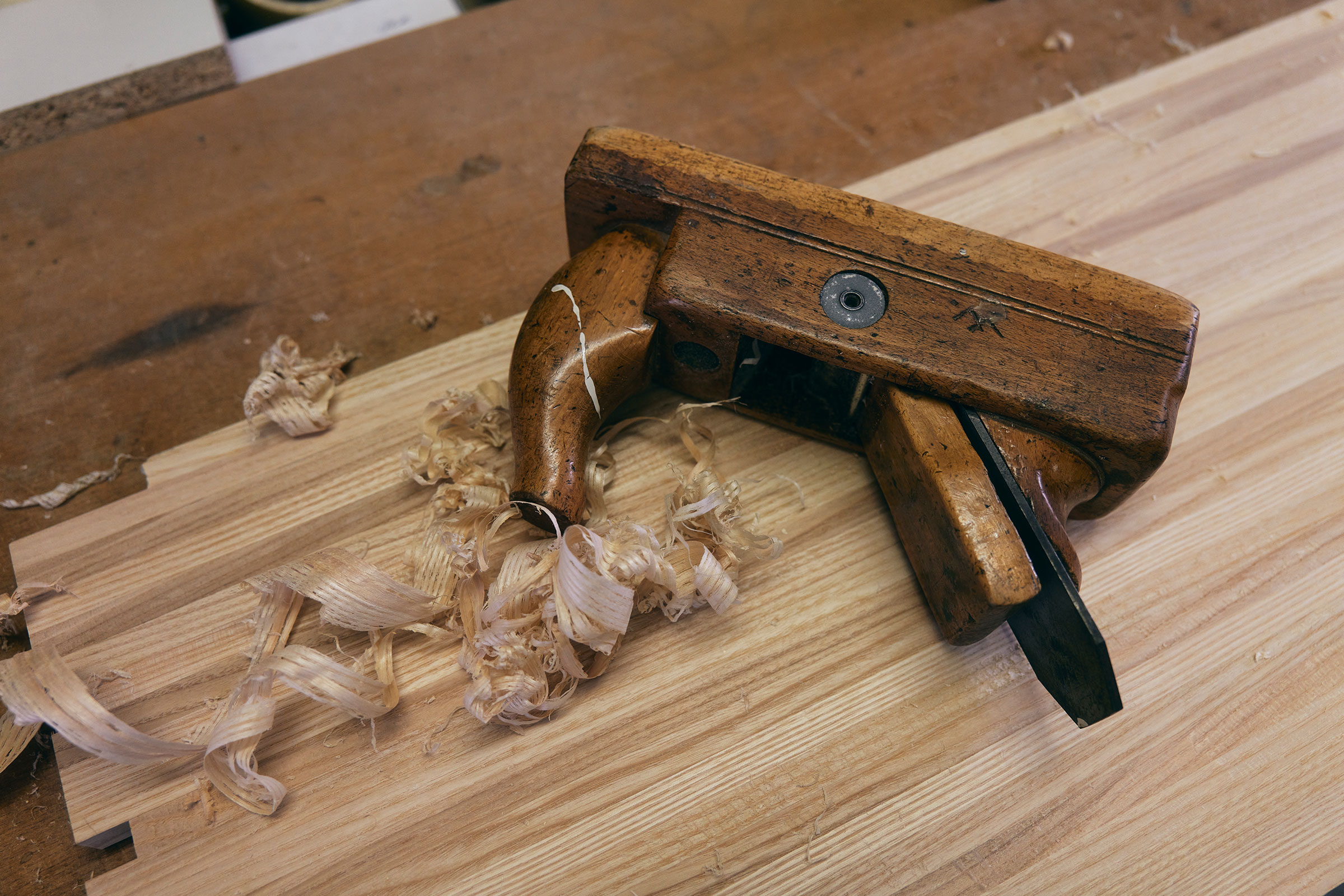 Hobel aus Holz mit Holzspänen auf einem Holzbrett