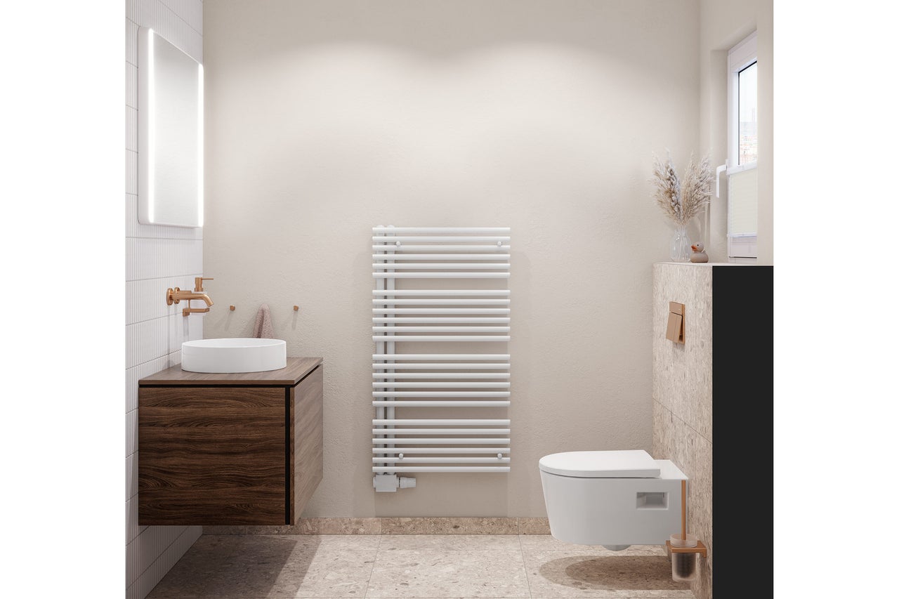 Salle de bains moderne et lumineuse avec meuble sous-vasque aspect bois foncé, vasque blanche, robinet en cuivre et radiateur sèche-serviettes.