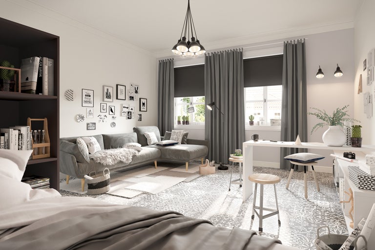 Salon avec canapé, bureau, chaises, étagères et éléments décoratifs pour une ambiance lumineuse et organisée.