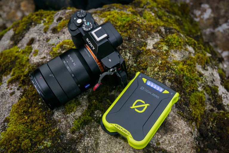 Sony Kamera neben einem Goal Zero Venture 30 Ladegerät auf einem moosbedeckten Stein