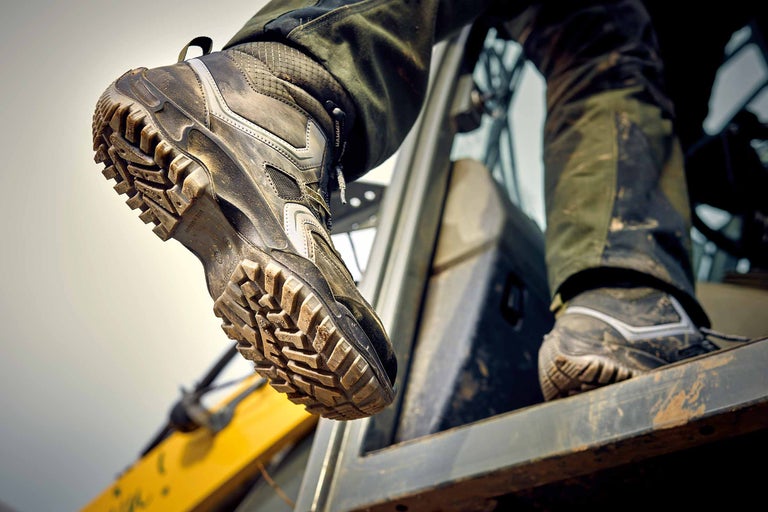 Gros plan d'une chaussure de travail sale avec un profil grossier