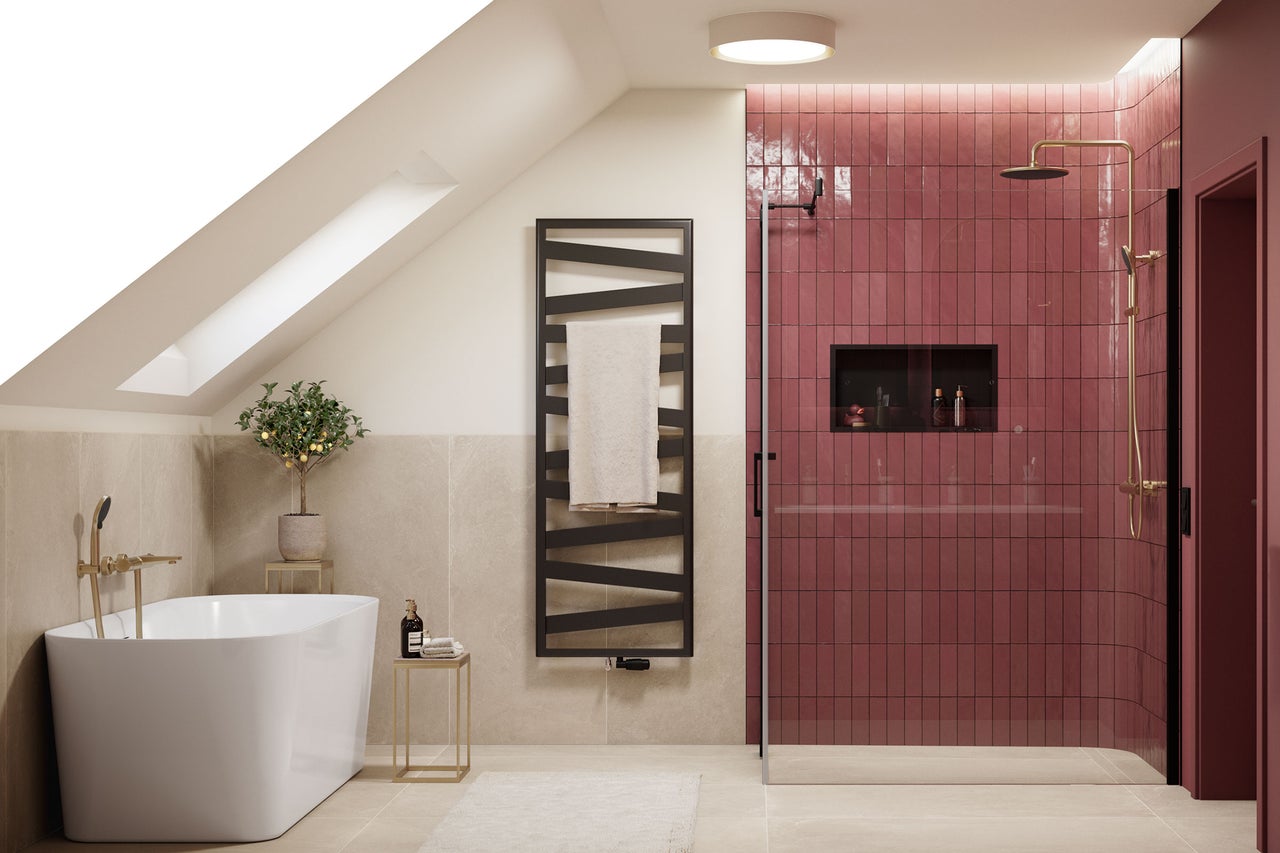 Salle de bains moderne sous les combles avec baignoire en ilot, douche a l italienne avec carreaux roses et radiateur seche-serviettes noir.