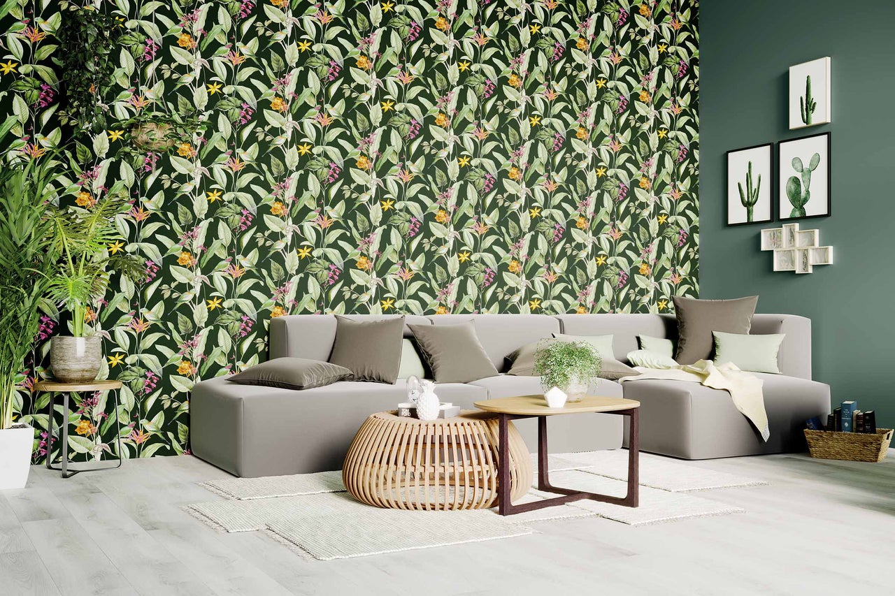 Salon avec canapé gris et papier peint jungle avec fleurs et feuilles