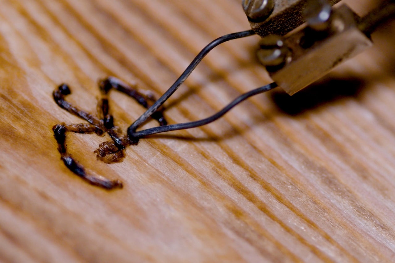 Gros plan d'un fer à souder décorant du bois
