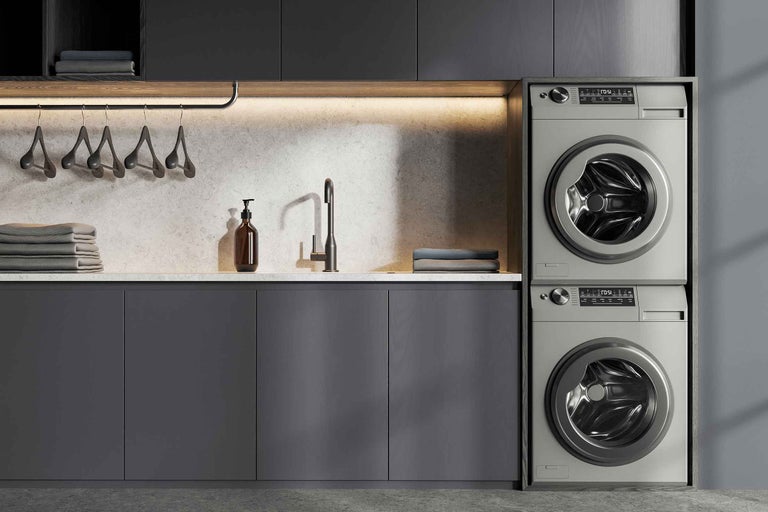 Buanderie moderne avec lave-linge, sèche-linge, évier et plan de travail