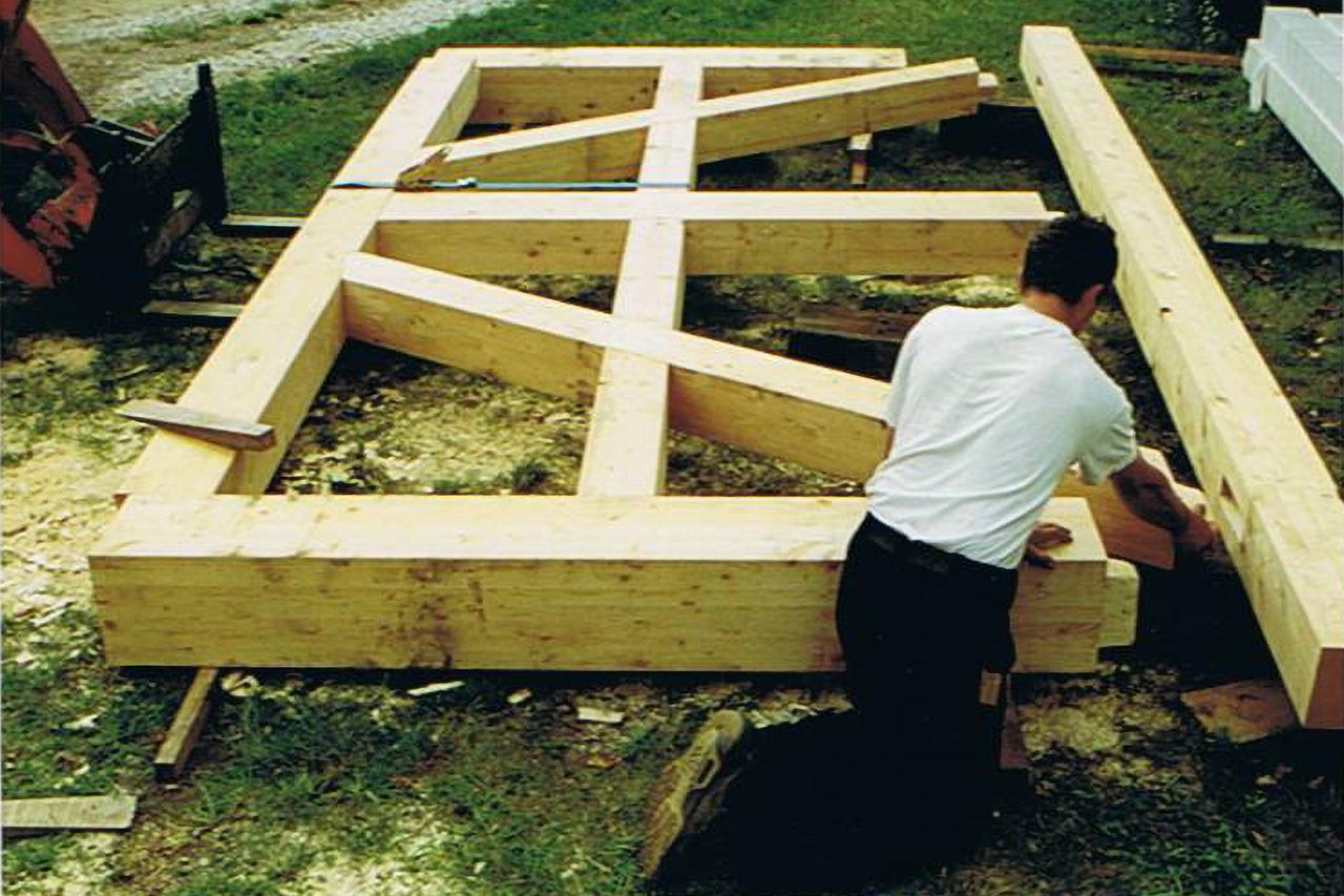 Construction de cadre en bois avec une personne construisant au sol