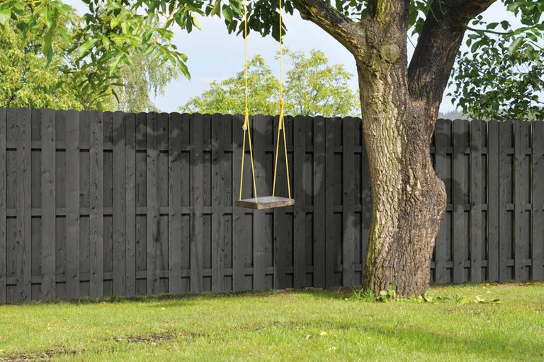 Scène avec une clôture en bois et une balançoire accrochée à un arbre