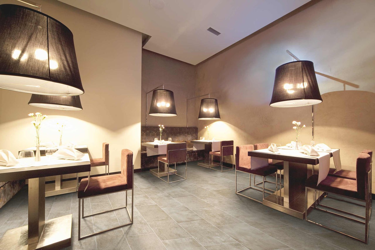Restaurant avec tables dressées et chaises sur carrelage