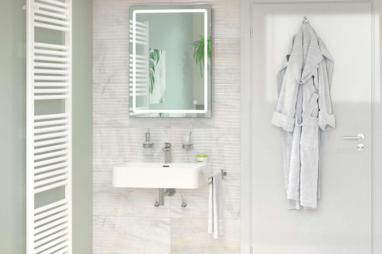 Salle de bain lumineuse avec lavabo, miroir éclairé, radiateur et peignoir sur la porte