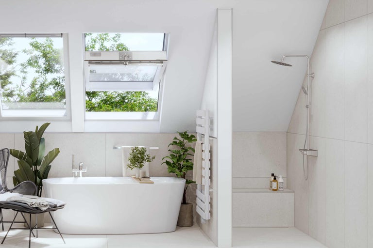 Salle de bain lumineuse avec fenêtres de toit, baignoire, douche et radiateur