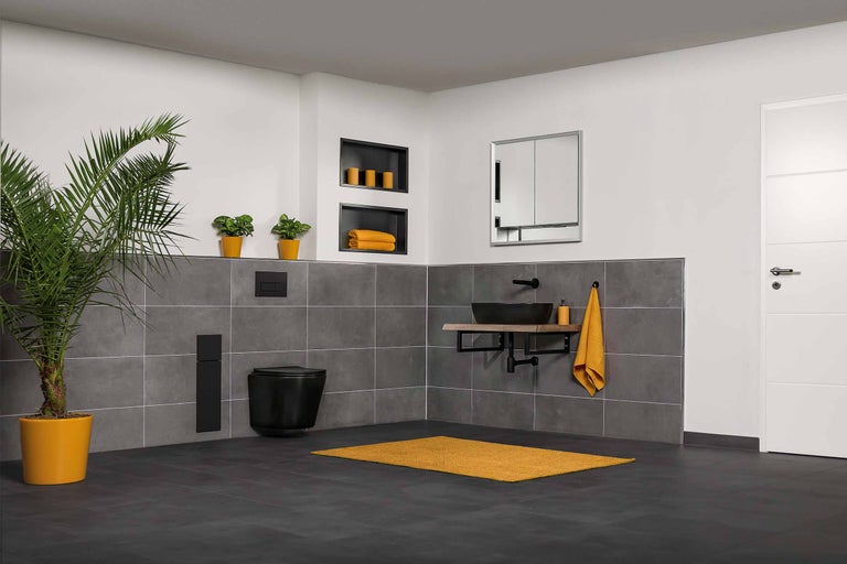 Modernes Badezimmer mit schwarzem wandhängendem WC, Waschbecken und grauen Fliesen