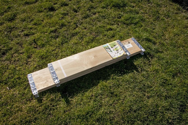 Paquet de planches en bois avec connecteurs métalliques sur l'herbe