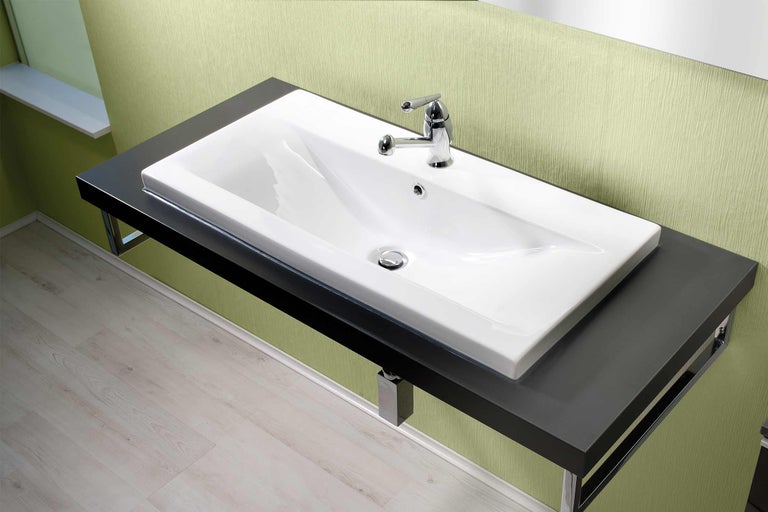 Lavabo avec plaque noire et lavabo blanc ainsi que robinetterie