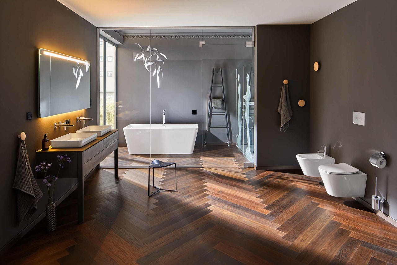 Salle de bains avec baignoire, douche, lavabo, toilettes et bidet dans des tons foncés
