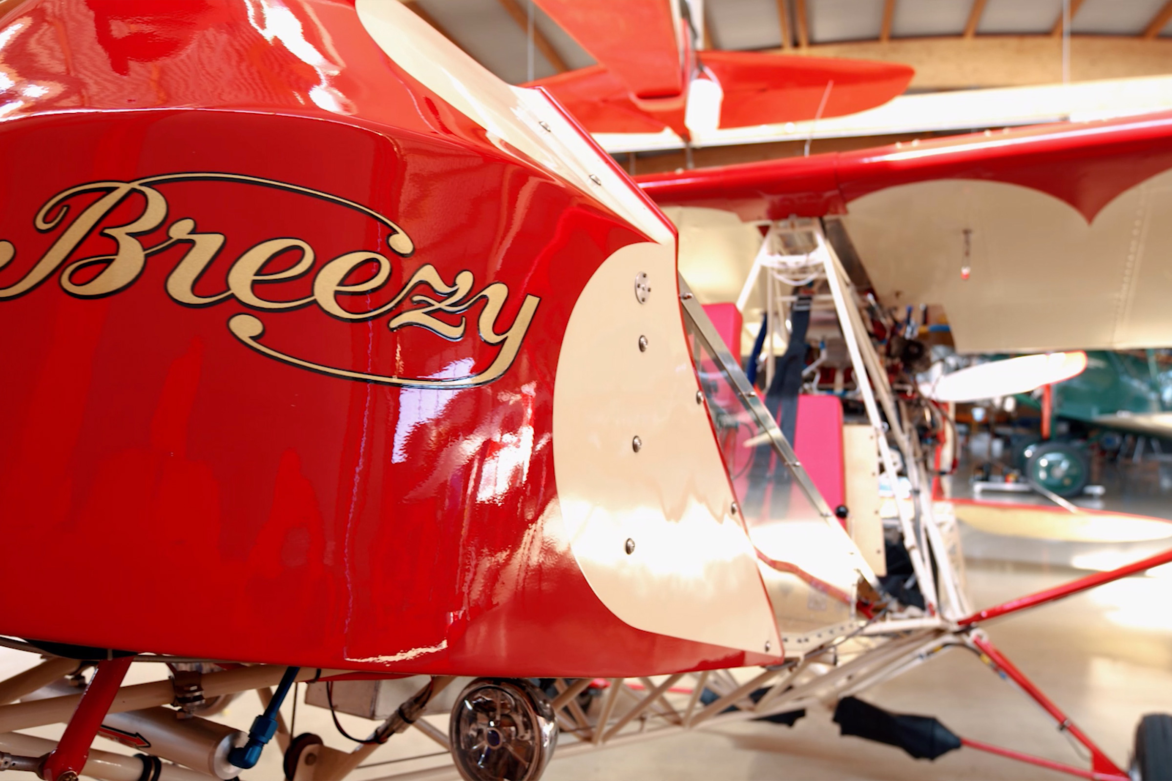 Detailansicht eines roten und weißen Flugzeugs mit dem Schriftzug Breezy.