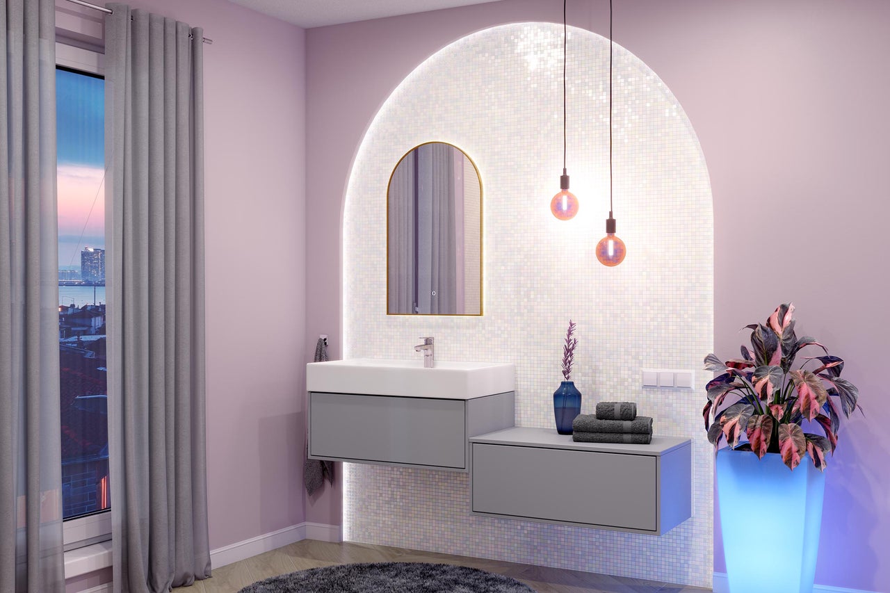 Salle de bain moderne avec meuble sous-vasque gris, lavabo blanc, miroir en arche et niche murale en mosaïque éclairée.