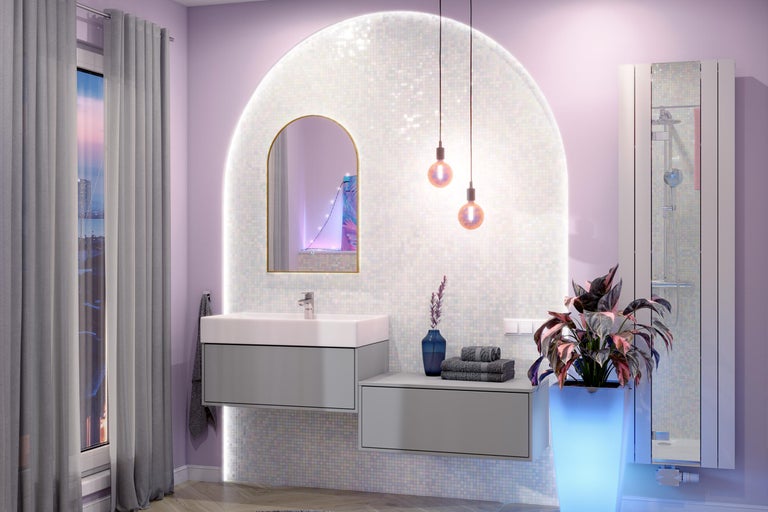Salle de bains moderne avec meuble sous vasque gris, lavabo blanc, miroir en arc et mur en mosaïque éclairé.