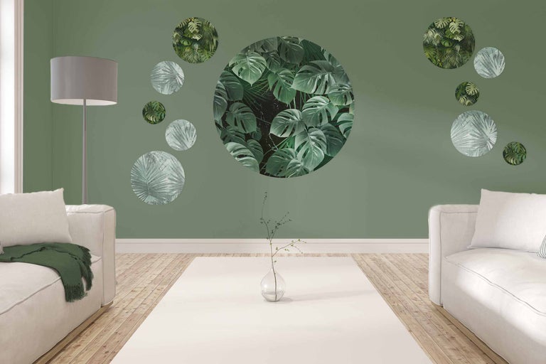 Salon avec canapés, lampadaire et décoration murale avec des motifs végétaux