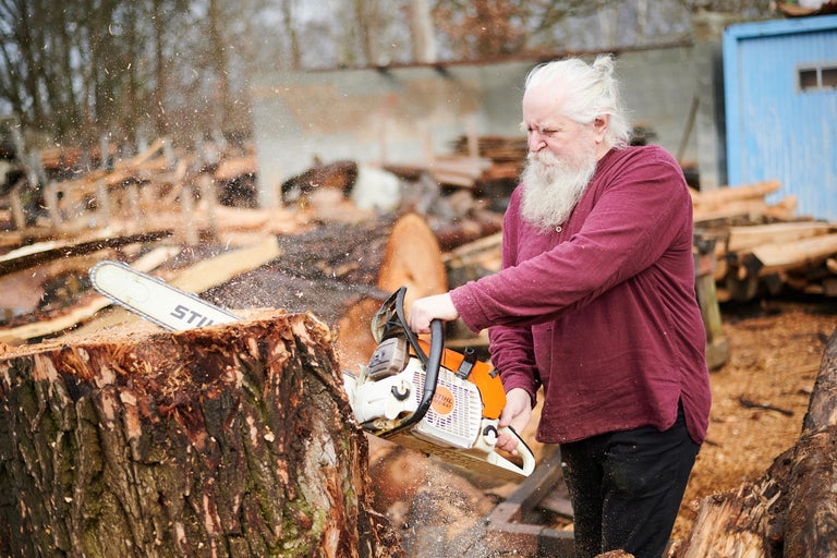 Mann sägt mit einer Stihl Kettensäge Holz