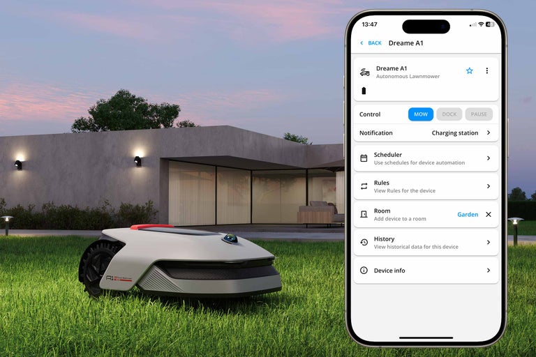 Une tondeuse à gazon autonome sur une pelouse avec une application smartphone au premier plan