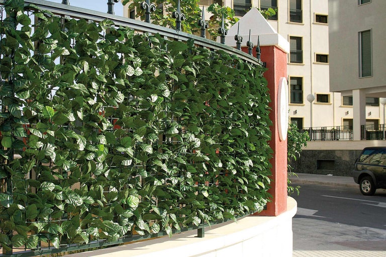 Clôture avec feuilles de lierre artificielles comme écran d'intimité
