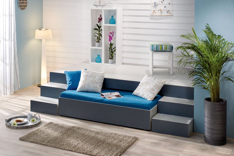 Salon avec lit à gradins, étagère, lampadaire et plante d'intérieur pour une ambiance claire et conviviale