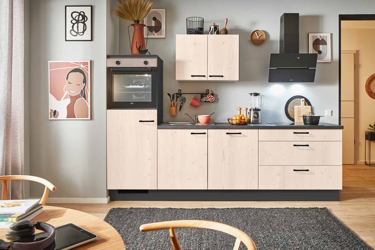 Cuisine moderne avec four encastrable, hotte aspirante et façades en bois clair