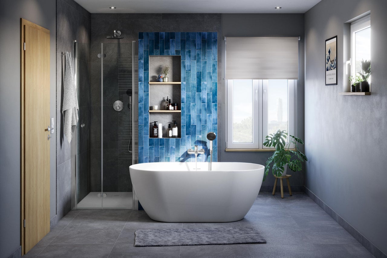 Salle de bain moderne avec baignoire îlot, douche et carreaux décoratifs bleus.