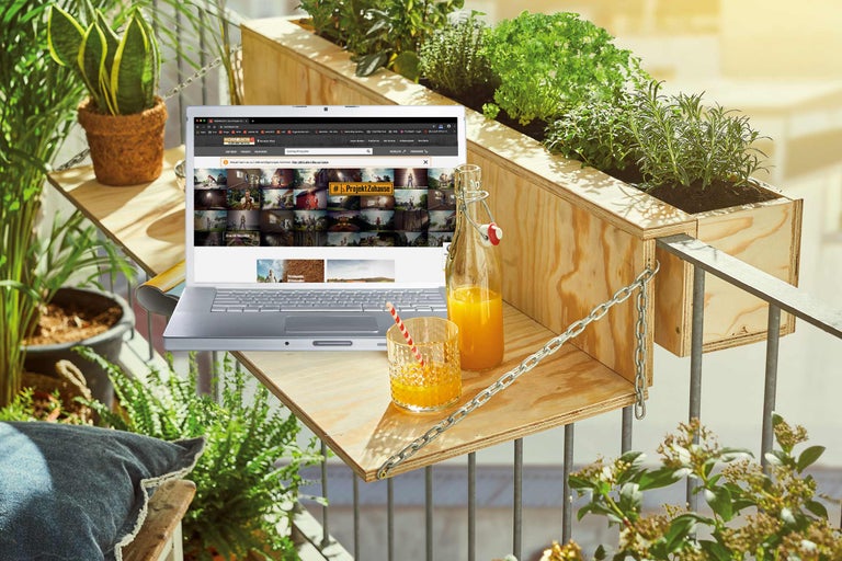 Scène de balcon avec des caissons en bois, un ordinateur portable et des boissons pour une atmosphère de détente