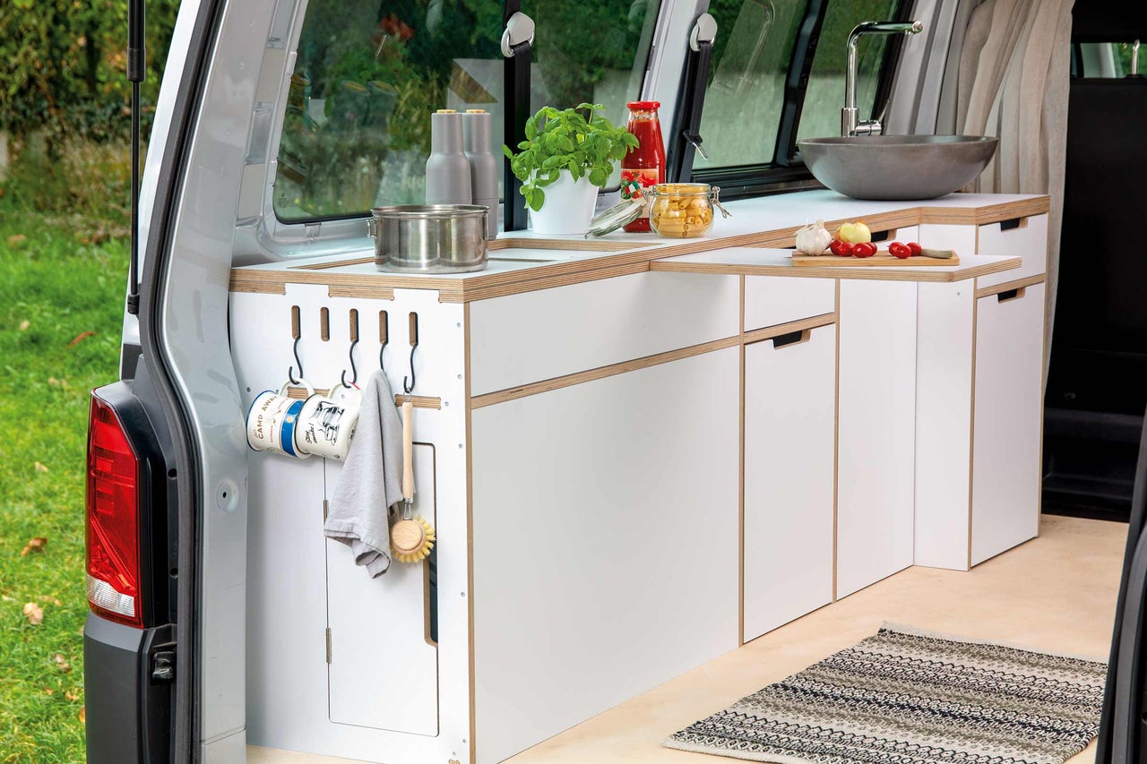 Cuisine intégrée dans un camping-car avec évier, plaque de cuisson, placards et plan de travail pour les voyages en camping