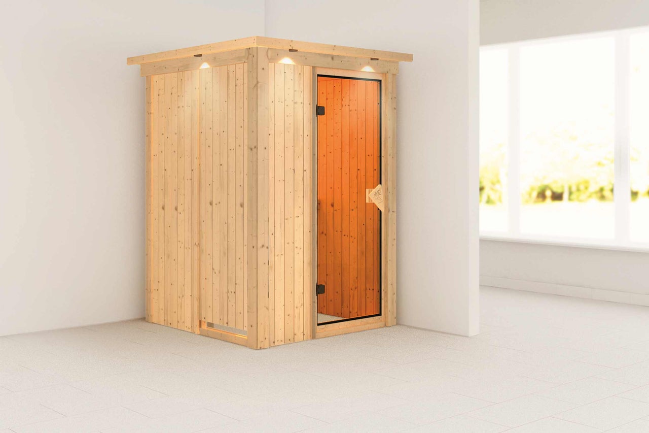 Sauna en bois avec porte en verre dans une pièce lumineuse