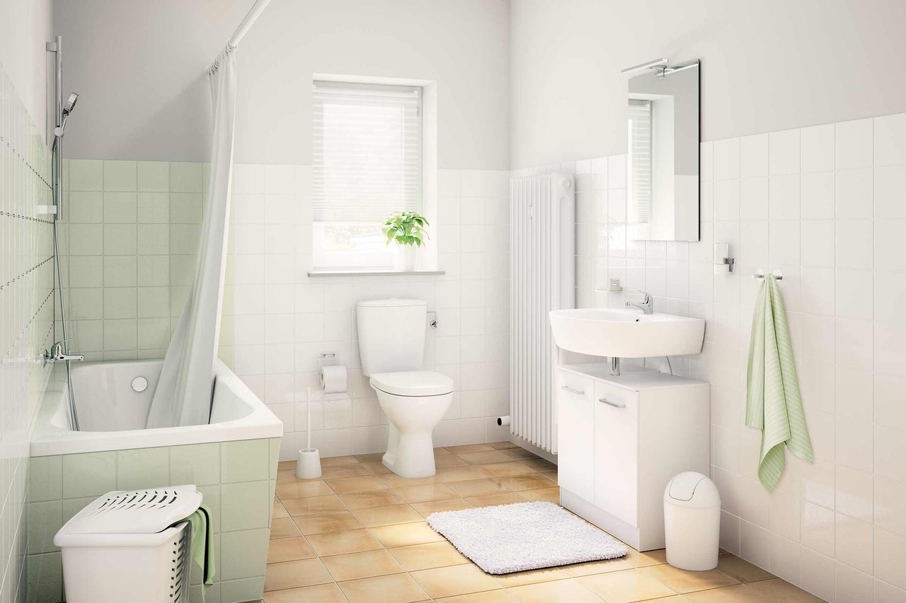 Salle de bain lumineuse avec baignoire, lavabo, toilettes et radiateur