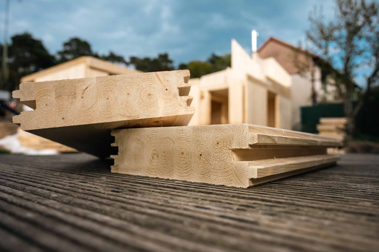 Madriers en bois massif avec profil à rainure et languette pour la construction d'un abri de jardin.