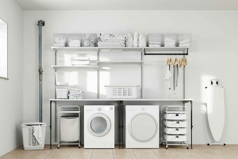 Buanderie claire avec lave-linge, sèche-linge, étagères et paniers à linge