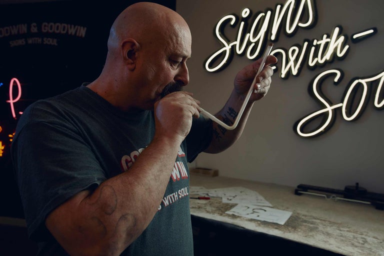 Ein Mann formt eine Neonröhre für eine Leuchtreklame.