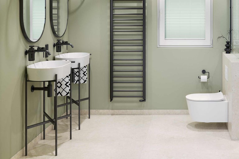 Salle de bain lumineuse avec double vasque, sèche-serviettes et WC suspendu.